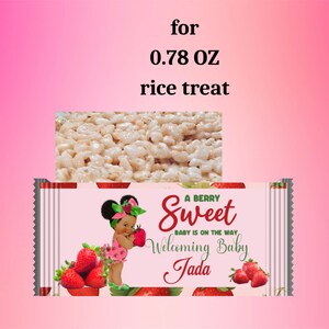 Puede incluir: Un envoltorio de arroz krispie treat rosa y blanco con un patr&oacute;n de fresas. El envoltorio presenta una ilustraci&oacute;n de dibujos animados de una ni&ntilde;a negra con un lazo verde en el pelo. El texto en el envoltorio dice "A Berry Sweet Baby is on the Way Welcoming Baby Jada".