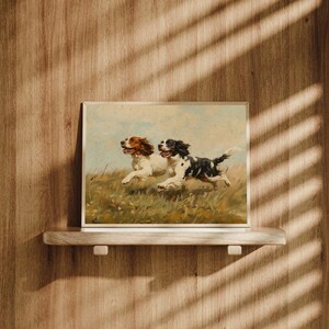 May include: A framed painting of two brown and white dogs running through a field of green grass. The dogs are running side by side, with their tongues out and their ears flapping in the wind.