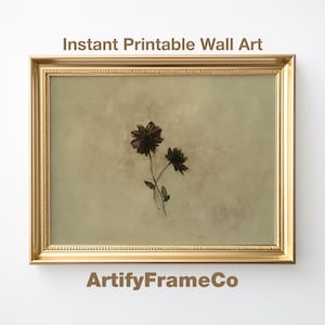 May include: A framed print featuring two dark maroon flowers with green stems against a muted beige background. The gold frame surrounds the artwork, with the text "Instant Printable Wall Art" and "ArtifyFrameCo" displayed.