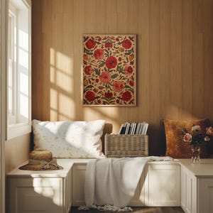 May include: A cozy interior scene featuring a framed floral artwork with red and pink blooms. A straw hat, pillows, and a woven basket are on a built-in bench. A soft blanket and a vase of roses add warmth.