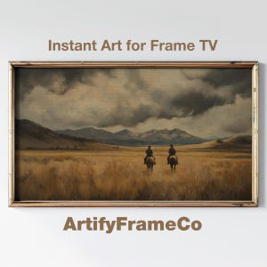 Op de afbeelding: Een ingelijst landschapsschilderij met twee ruiters te paard in een veld. De lucht is bedekt met donkere wolken en bergen zijn zichtbaar in de verte. De tekst "Instant Art for Frame TV" en "ArtifyFrameCo" worden weergegeven.