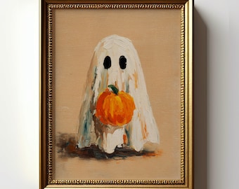 Puede incluir: Una impresión de arte mural enmarcada con una pintura al óleo de un fantasma blanco que sostiene una calabaza naranja brillante. El fantasma tiene dos ojos ovalados negros y está centrado sobre un fondo beige. La obra tiene un marco dorado.