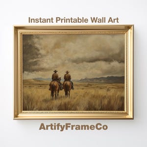 May include: A framed print featuring two cowboys on horseback, set against a backdrop of a vast, grassy plain under a cloudy sky. The artwork is in warm, earthy tones, with the text "Instant Printable Wall Art" and "ArtifyFrameCo".
