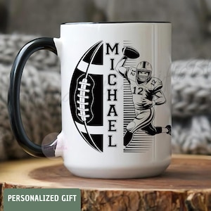 May include: White ceramic mug with a black handle and rim. The mug features a black and white graphic of a football and a football player, with the name "MICHAEL" in vertical text. The words "PERSONALIZED GIFT" are at the bottom.