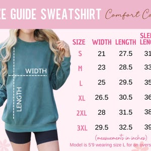 Puede incluir: Tabla de tallas para una sudadera con medidas en pulgadas para el ancho, la longitud y la longitud de la manga. La tabla muestra las tallas S a 3XL. La modelo lleva la talla L.