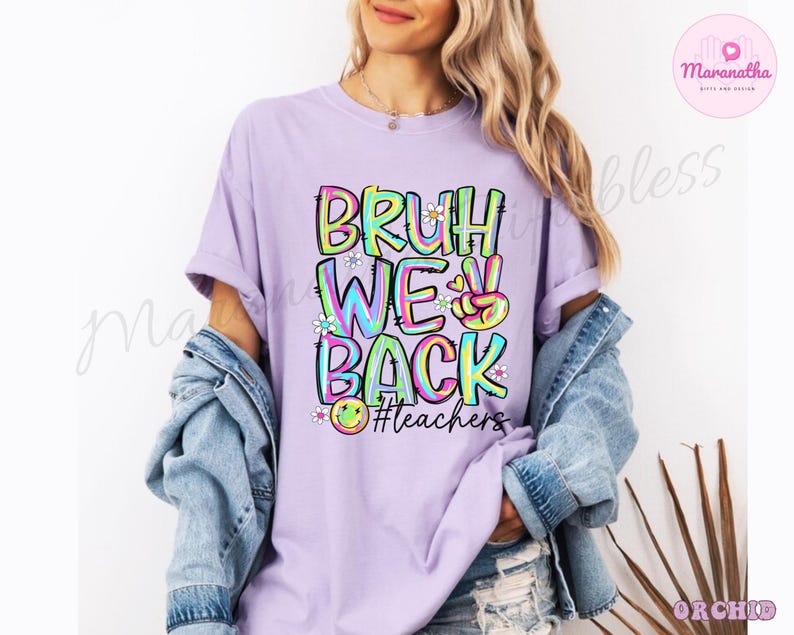 K&ouml;nnte beinhalten: Ein helllila T-Shirt mit den Worten "BRUH WE BACK" in einem farbenfrohen Graffiti-Design. Das Shirt zeigt auch ein Friedenszeichen und den Hashtag #teachers.