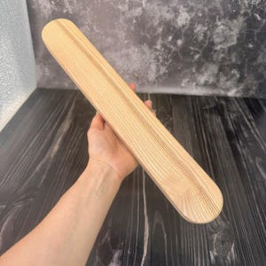 Puede incluir: Una taza de cerámica blanca con un asa negra y el texto "But First, Coffee" en negrita negra. La taza se encuentra sobre un fondo neutro, resaltando su diseño simple.