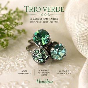 May include: Three stackable rings with green Austrian crystals. The rings are made of stainless steel and are adjustable from size 4.5 to 7. The image includes the text "TRIO VERDE" and "Fleublevue".