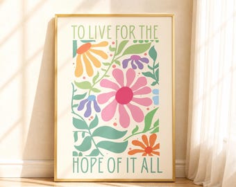 Op de afbeelding: Een rechthoekige wandprint in een gouden lijst met een crèmekleurige achtergrond en groene tekst die TO LIVE FOR THE HOPE OF IT ALL luidt. Het ontwerp bevat kleurrijke gestileerde bloemen in roze, geel, oranje en paars met groene bladeren.