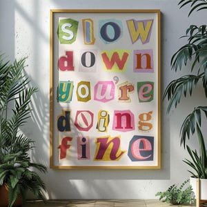 May include: A colorful poster with the text "Slow down you're doing fine" in a cut-out style font.