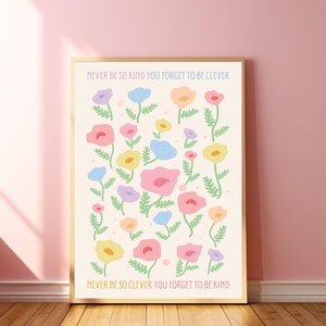 A white poster with a floral pattern of pink, blue, yellow, and orange flowers. The text on the poster reads "NEVER BE SO KIND YOU FORGET TO BE CLEVER" and "NEVER BE SO CLEVER YOU FORGET TO BE KIND".
