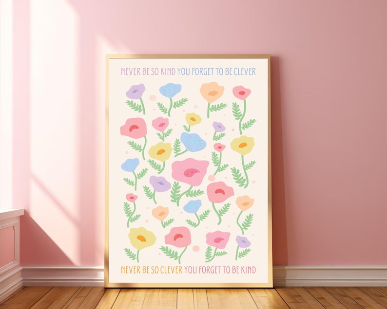 A white poster with a floral pattern of pink, blue, yellow, and orange flowers. The text on the poster reads "NEVER BE SO KIND YOU FORGET TO BE CLEVER" and "NEVER BE SO CLEVER YOU FORGET TO BE KIND".
