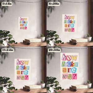 May include: A poster with the text "how lucky are we?" in colorful, cut-out style letters. The poster is displayed in four different sizes: 11x14 inches, 16x20 inches, 18x24 inches, and 20x30 inches. The background is a neutral color.