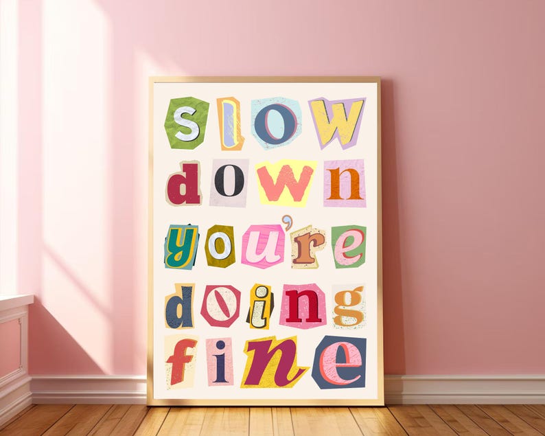 May include: A framed print with the text "slow down you're doing fine" in colorful, cut-out letters on a white background.