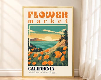 May include: A rectangular wall art print in a gold frame featuring the text FLOWER market and CALIFORNIA State Flower - California Poppy. The illustration depicts a coastal landscape with orange poppies in the foreground and a sunset over the sea.