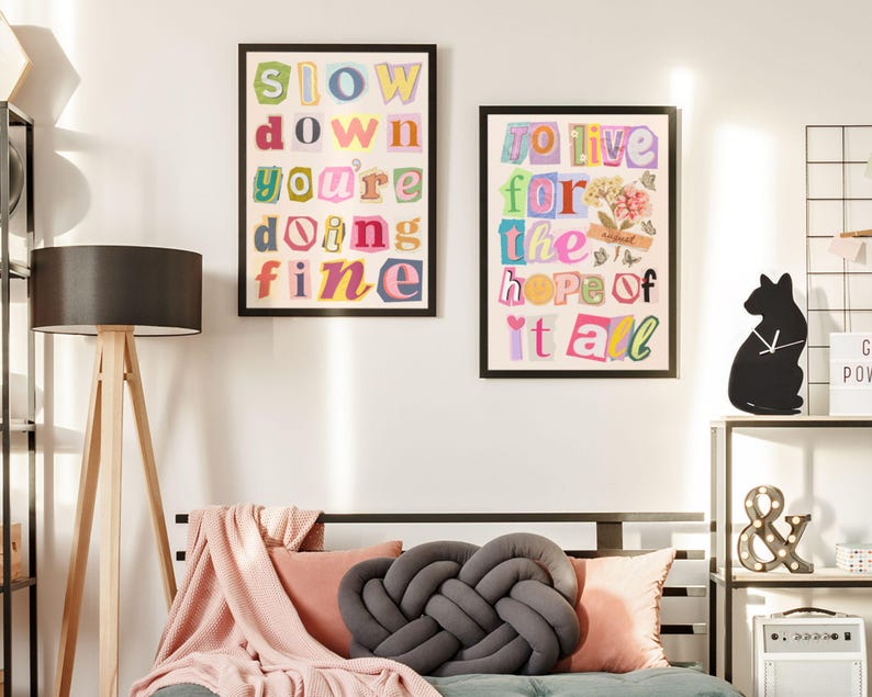 May include: Two framed prints with colorful text on a white wall. The print on the left says "Slow down you're doing fine". The print on the right says "To live for the hope of it all".