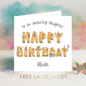 May include: A square greeting card with the text 'to an amazing daughter' and 'HAPPY BIRTHDAY' spelled out using brown capybara illustrations. The name 'Olivia' is printed below. Each letter-shaped capybara features small decorative elements.