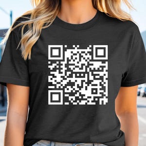 a woman wearing a black t - shirt with a qr code on it