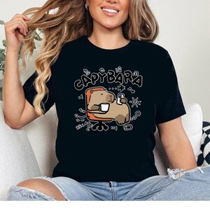 a woman sitting on a couch wearing a black shirt