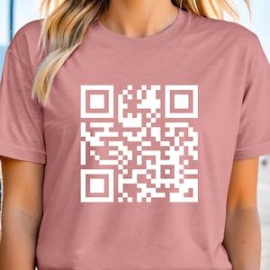a woman wearing a pink shirt with a qr code on it