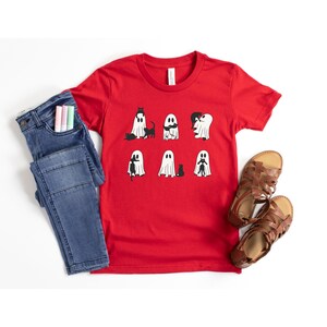 a red shirt with ghost faces on it next to a pair of jeans