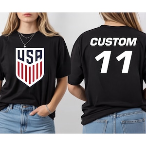 A woman wearing a black t-shirt with the USA logo and the number 11 on the back.