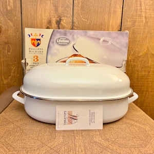 May include: A white oval enamel roaster pan with a matching lid and side handles. The pan is positioned in front of its original product box, which features the Philippe Richard Collections logo, a 3-piece set label, and a limited lifetime warranty.