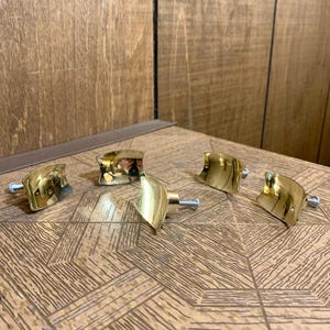 May include: A white ceramic mug with a black handle and the text "But First, Coffee" in a black, handwritten-style font. The mug is on a white surface.