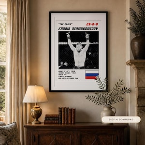 May include: A framed poster featuring a black and white photograph of Khabib Nurmagomedov with arms raised. Text includes "The Eagle", "29-0-0", "Khabib Nurmagomedov", height 5' 10", weight 155lbs, reach 70", stance orthodox, DOB 20th September 1988, and a Russian flag.