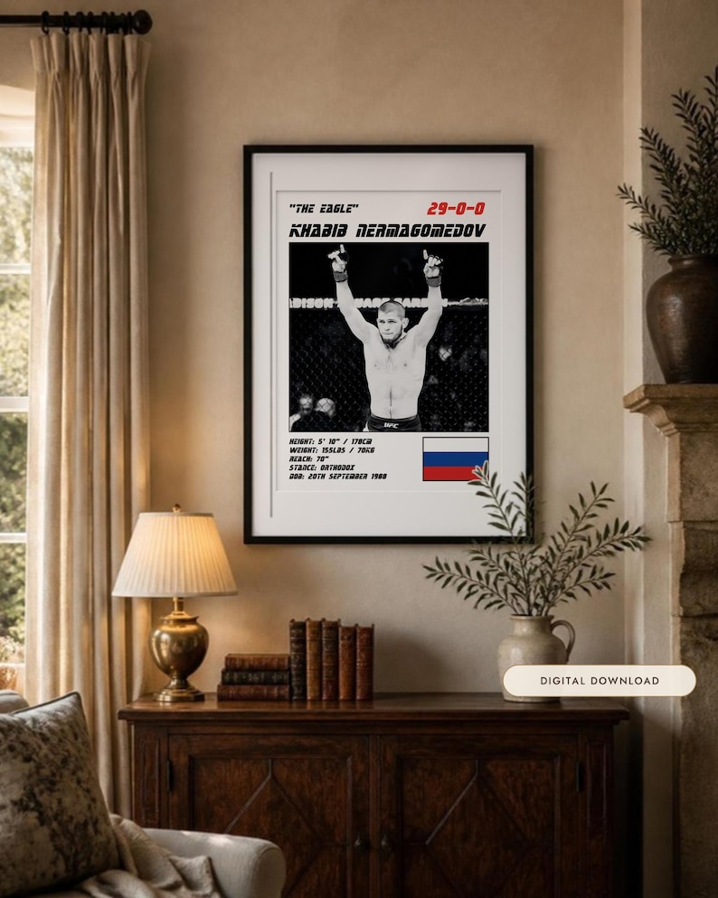 May include: A framed poster featuring a black and white photograph of Khabib Nurmagomedov with arms raised. Text includes "The Eagle", "29-0-0", "Khabib Nurmagomedov", height 5' 10", weight 155lbs, reach 70", stance orthodox, DOB 20th September 1988, and a Russian flag.