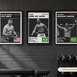 May include: Three framed posters featuring black and white photographs of MMA fighters Stipe Miocic, Junior Dos Santos, and Minotauro Nogueira. Each print includes the fighter's name, record, physical stats in imperial units, and a national flag.