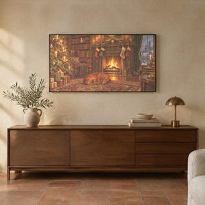 May include: A rectangular wall art print depicting a cozy living room scene with a fireplace, a decorated Christmas tree, and a dog sleeping on a rug. The artwork is displayed above a long, dark wood sideboard with three drawers and two doors.