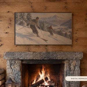 May include: A rectangular framed wall art print featuring a vintage-style painting of two people skiing down a snowy mountain slope with pine trees and distant peaks, displayed above a stone fireplace with a digital download label.