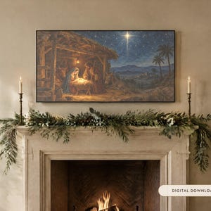 May include: A rectangular wall art print depicting a nativity scene with figures in a stable under a bright star, displayed above a fireplace mantel decorated with green pine garland and two tall brass candlesticks with lit candles.