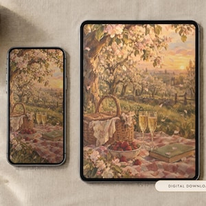May include: A smartphone and a tablet displaying a digital illustration of a picnic scene under blooming trees. The artwork features a wicker basket, a bowl of strawberries, two glasses of champagne, and a book on a red and white chequered blanket.