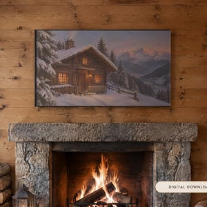 May include: A rectangular wall art print featuring a snowy mountain landscape with a wooden cabin, pine trees, and glowing windows. The artwork is displayed above a stone fireplace with a burning fire and a stack of firewood nearby.