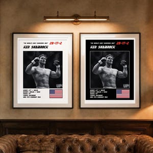 May include: Two framed posters featuring Ken Shamrock in a black and white photograph with arms raised. Text includes "The World's Most Dangerous Man", "28-17-2", "Ken Shamrock", stats like "Height: 6'1" / 185cm", "Weight: 205lbs / 93kg", "Reach: 73"", "Stance: Orthodox", "DOB: 11th February 1964", and a US flag.