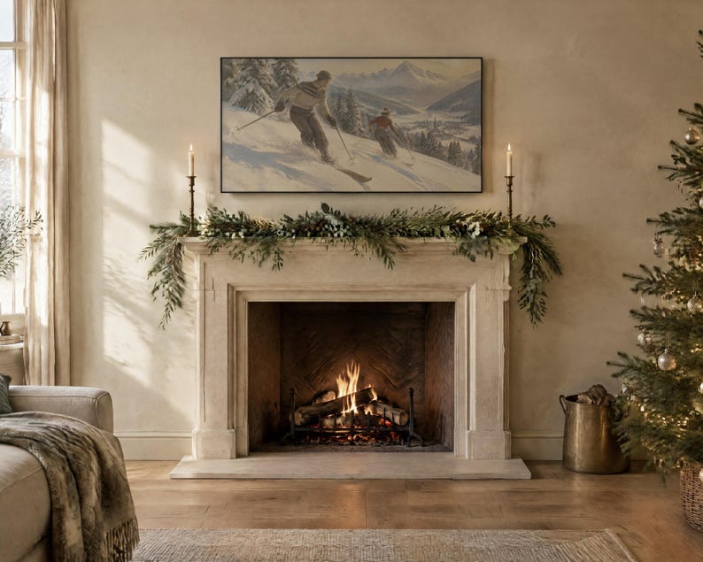 May include: A stone fireplace mantel features a green pine garland and two tall candlesticks. Above the mantel hangs a framed landscape painting of two skiers on a snowy mountain. A fire burns in the hearth, and a Christmas tree stands nearby.