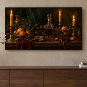 Puede incluir: Un bodeg&oacute;n enmarcado muestra una mesa de madera oscura con un decantador de cristal con l&iacute;quido rojo, una copa de vino, tres velas encendidas en candelabros de lat&oacute;n, cuencos con naranjas con clavos, nueces y cintas de terciopelo rojo.