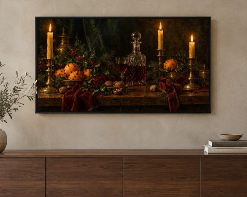 Puede incluir: Un bodeg&oacute;n enmarcado muestra una mesa de madera oscura con un decantador de cristal con l&iacute;quido rojo, una copa de vino, tres velas encendidas en candelabros de lat&oacute;n, cuencos con naranjas con clavos, nueces y cintas de terciopelo rojo.