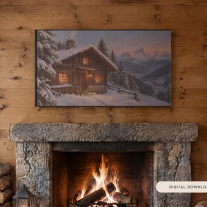 May include: A rectangular wall art print featuring a snowy mountain landscape with a wooden cabin, pine trees, and a glowing window. The artwork is displayed above a stone fireplace with a burning fire and a stack of firewood nearby.