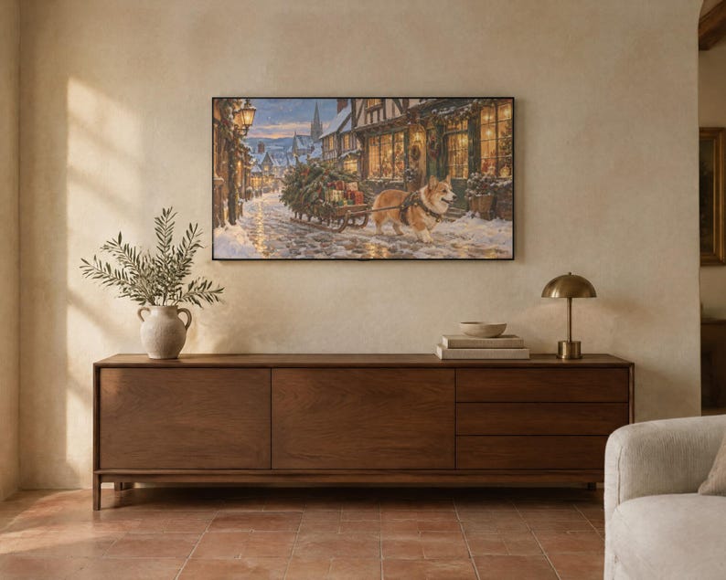 May include: A rectangular wall art print depicting a snowy village street scene with a corgi pulling a small wooden sled loaded with a Christmas tree and gifts, displayed above a long, dark brown wooden sideboard with three drawers.
