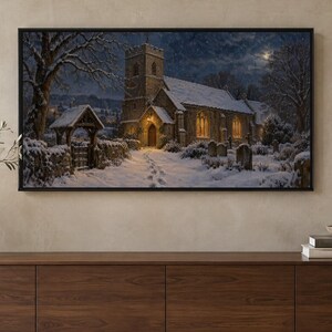 May include: A rectangular framed wall art print depicting a stone church at night during winter. The scene features snow-covered grounds, a path with footprints leading to the entrance, glowing yellow windows, and a dark, starry sky.