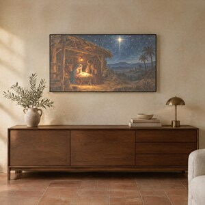 May include: A rectangular wall art print depicting a nativity scene with a glowing star in a dark blue night sky, mounted above a long, dark brown wooden sideboard featuring three drawers and two cabinet doors with a smooth finish.