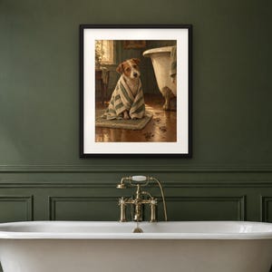 May include: A framed wall art print depicting a brown and white terrier dog wrapped in a green and white striped towel, sitting on a bathroom rug next to a clawfoot bathtub with muddy paw prints on the wooden floorboards.