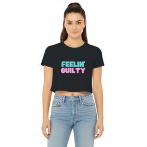 May include: Black crop top with the text "FEELIN' GUILTY" in a gradient of blue and pink. The shirt is made of a soft material and is a casual style.
