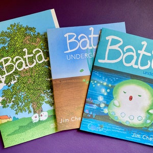 May include: Three different covers of a comic book series called "Bata". The first cover is blue with a green tree and two white birds. The second cover is blue with a brown field and the text "Bata UNDERGROUND". The third cover is blue with a green creature in the water and the text "Bata underwater".