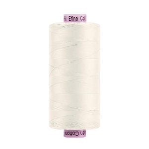 May include: A spool of off-white sewing thread with light purple end caps. The top cap features the text "Fil Efina Col." and the bottom cap features the text "ian Cotton". The thread is wound tightly around the cylindrical spool body.