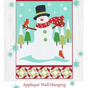 May include: Appliqué wall hanging featuring a snowman with a black top hat, red scarf, and red buttons. The snowman is standing in a snowy landscape with green trees and red cardinals. The text "Believe" is written in red letters at the top of the image. The image is from The Quilt Factory and is 30x48 inches.