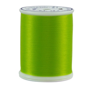May include: A spool of bright green thread for sewing or embroidery.
